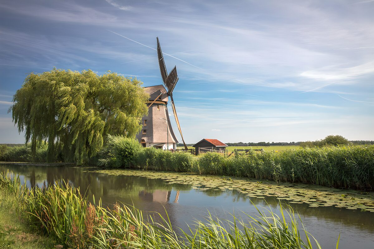 Molino de viento junto al canal en calma