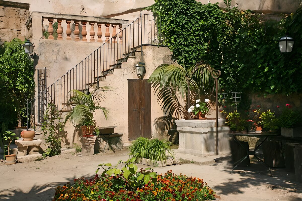 Patio con pozo y flores al sol