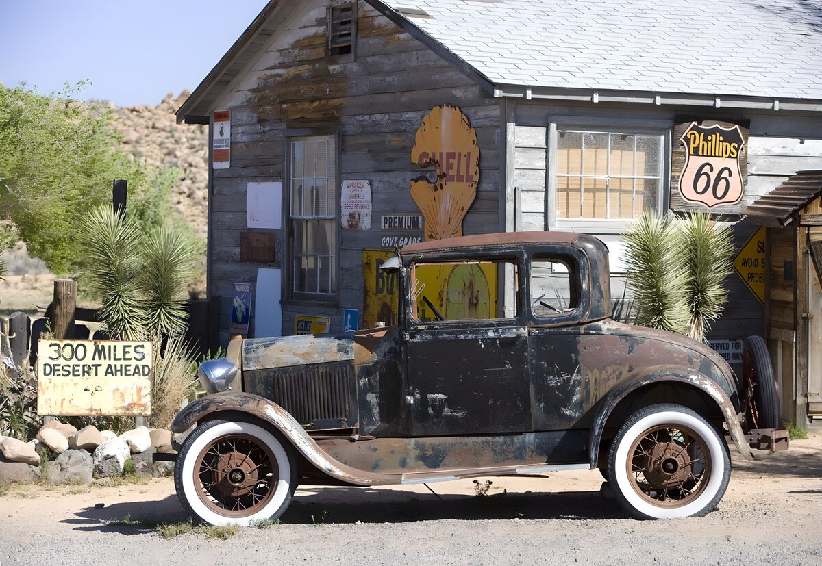 Coche oxidado ante una fachada de madera