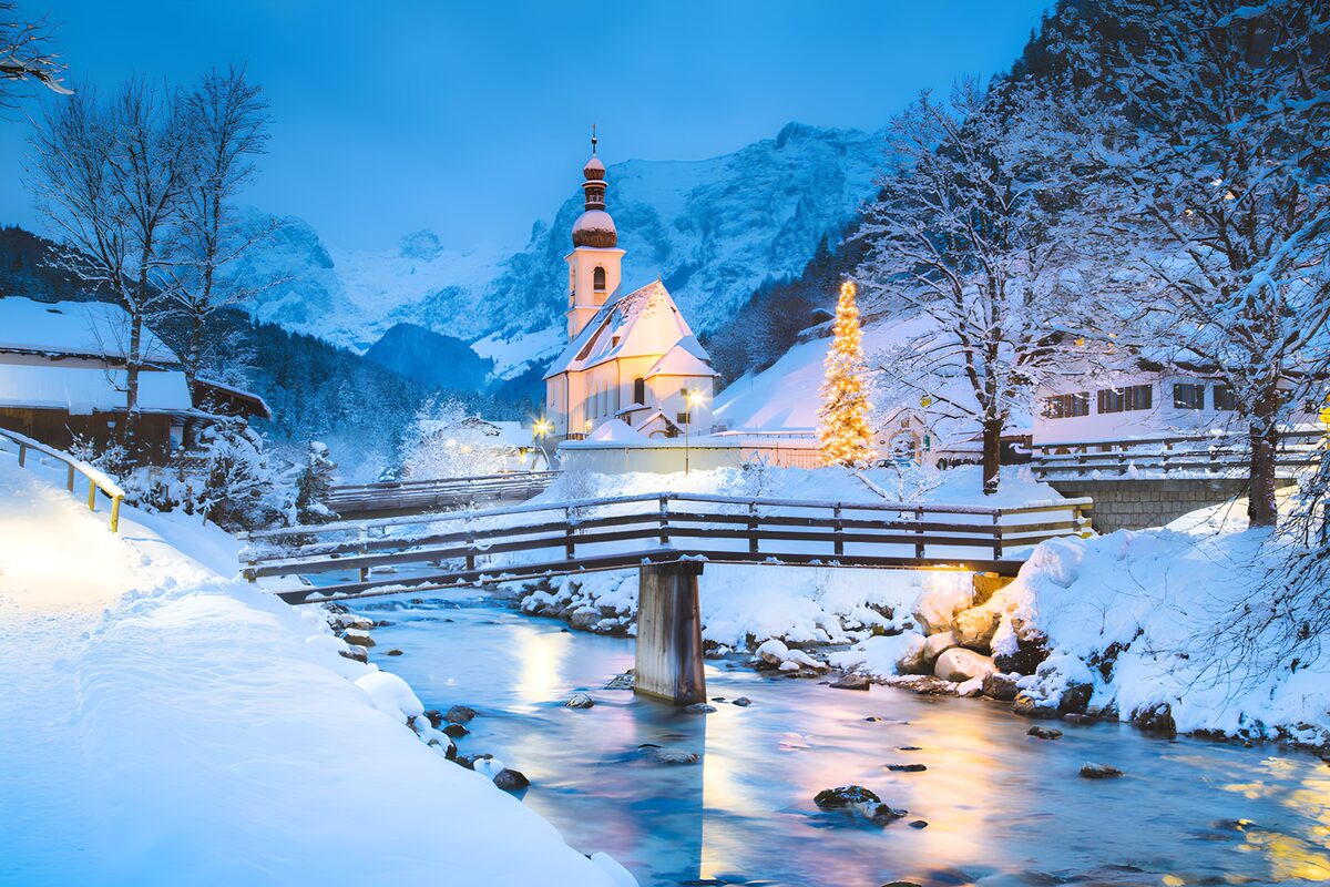 Iglesia y arroyo en la nieve al anochecer