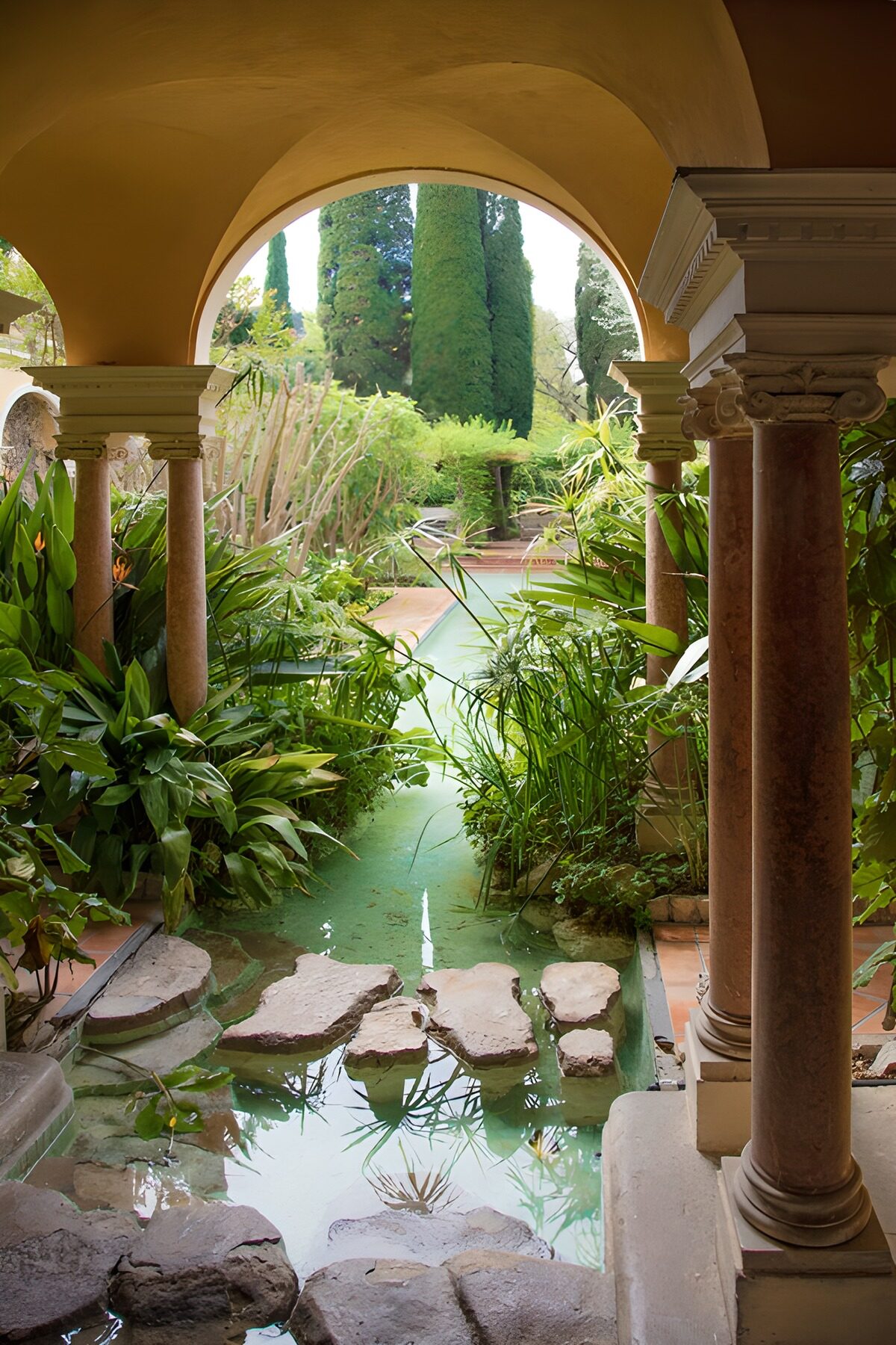 Jardín con estanque bajo un arco ocre