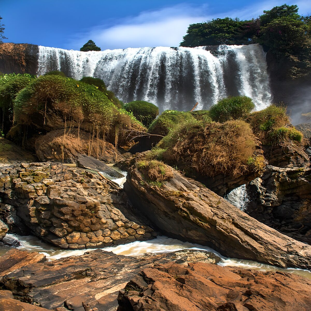 Cascada entre rocas bajo el sol