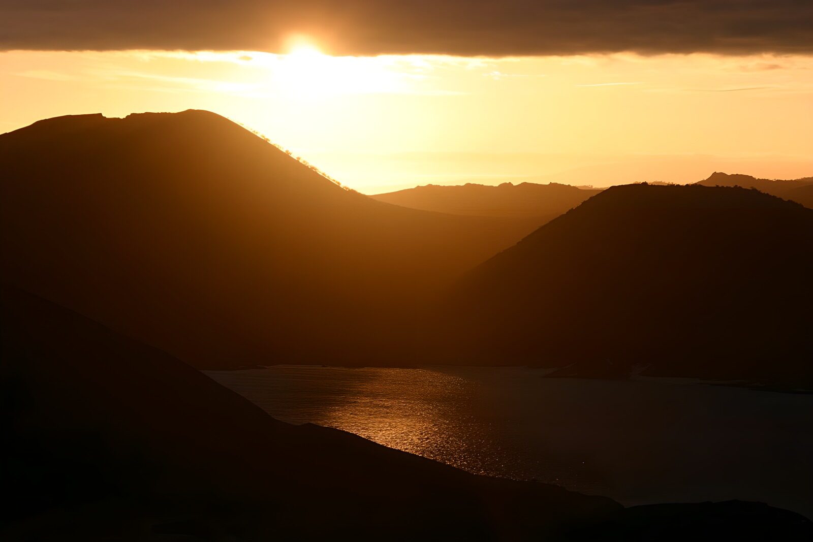 TPES42787: Sol bajo entre montañas y agua dorada