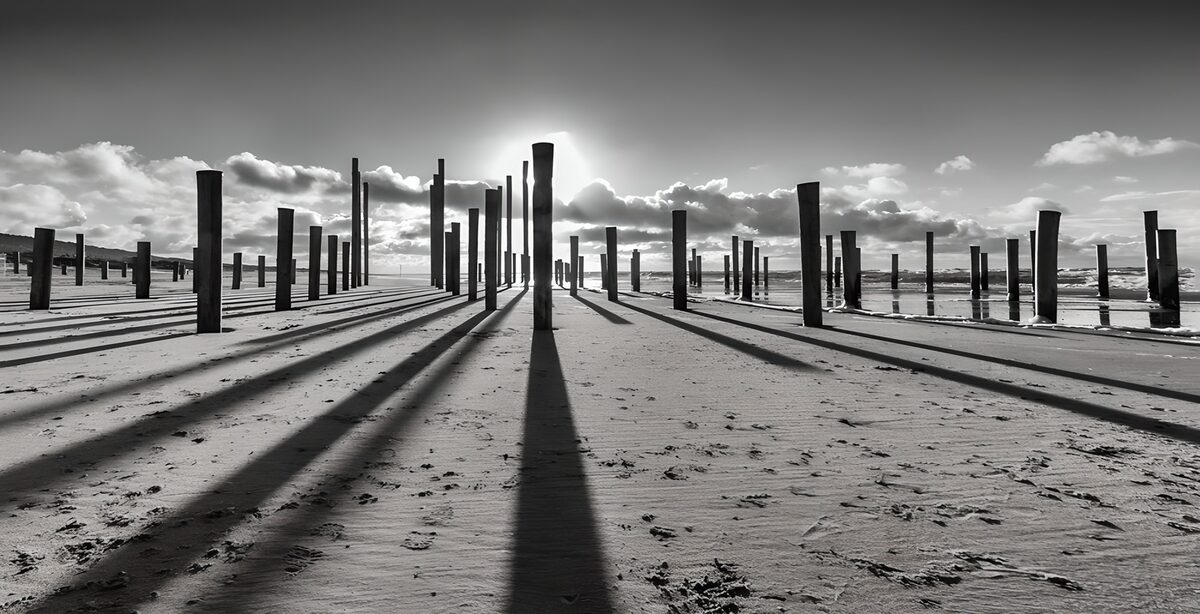 Postes y largas sombras en la playa