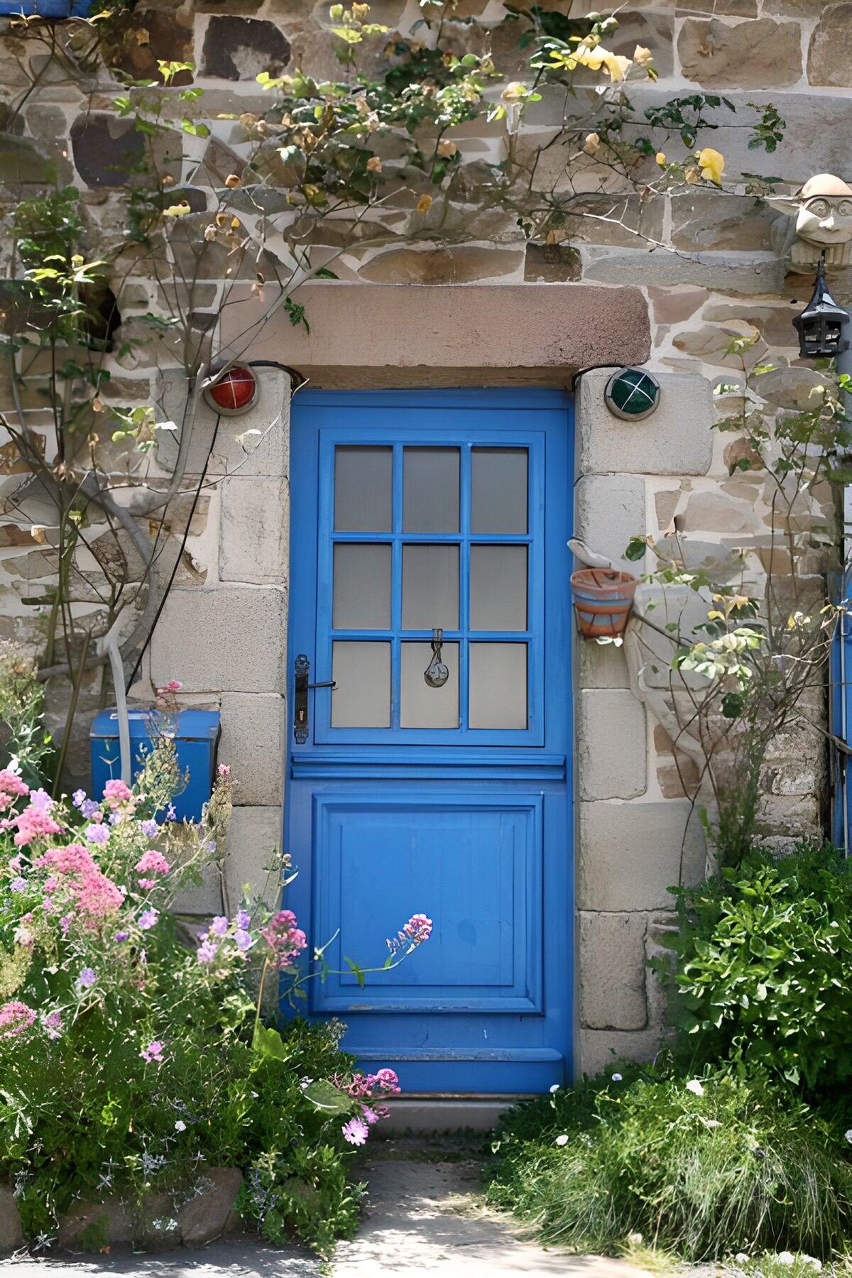 Puerta azul entre piedra y flores