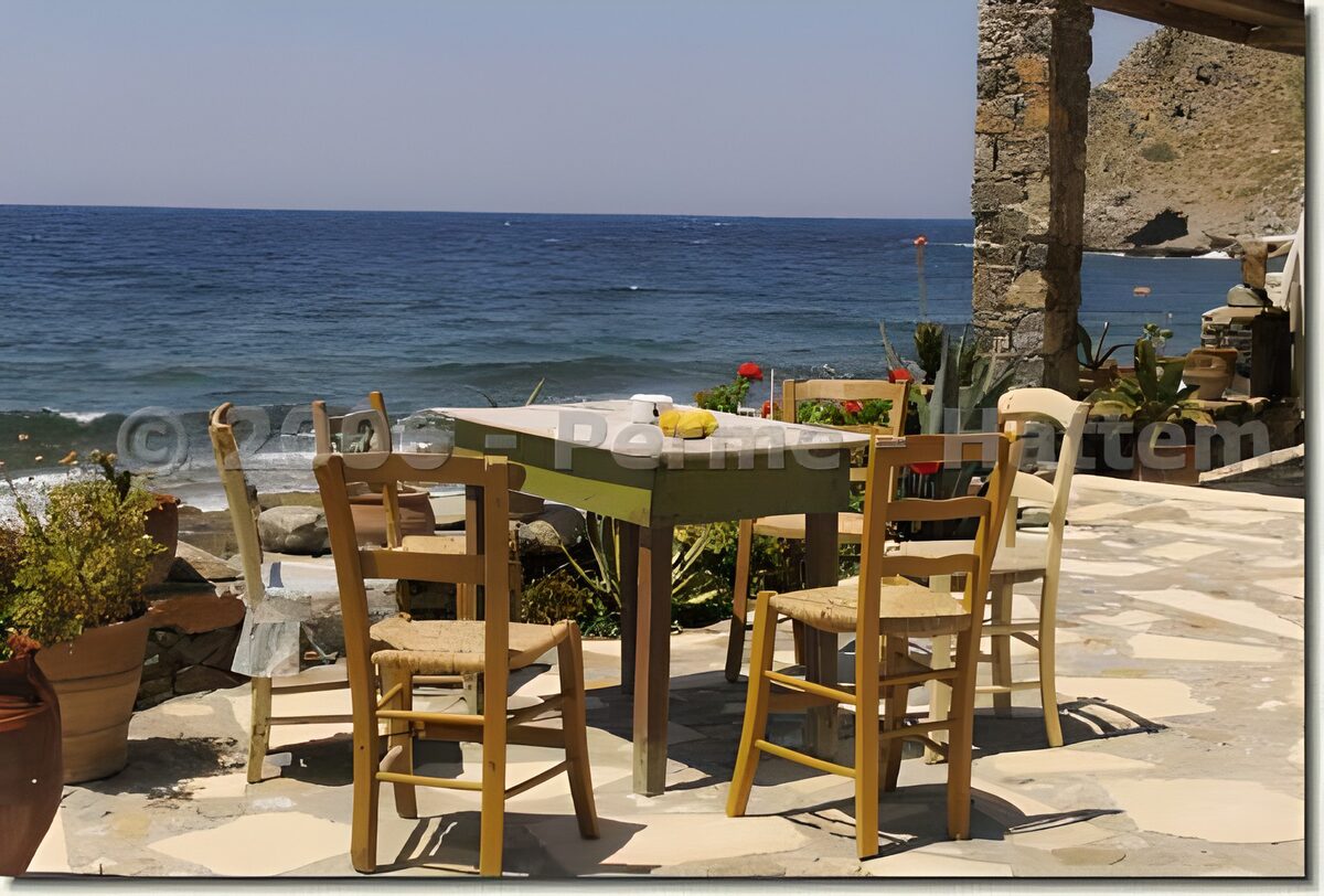 Terraza con mesa verde junto al mar