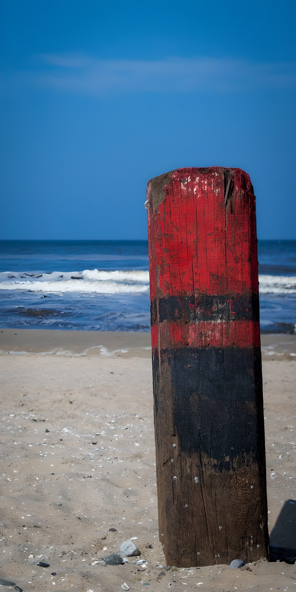 TPES35104: Poste rojo y negro en la playa