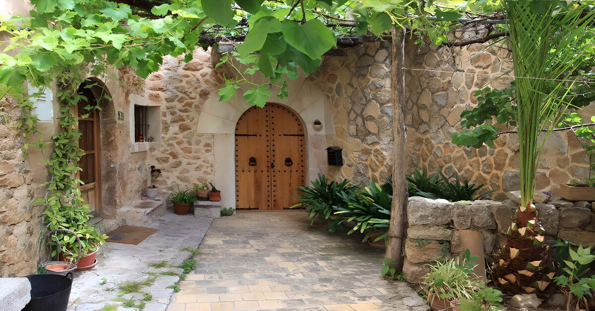 Patio de piedra con puerta bajo las hojas