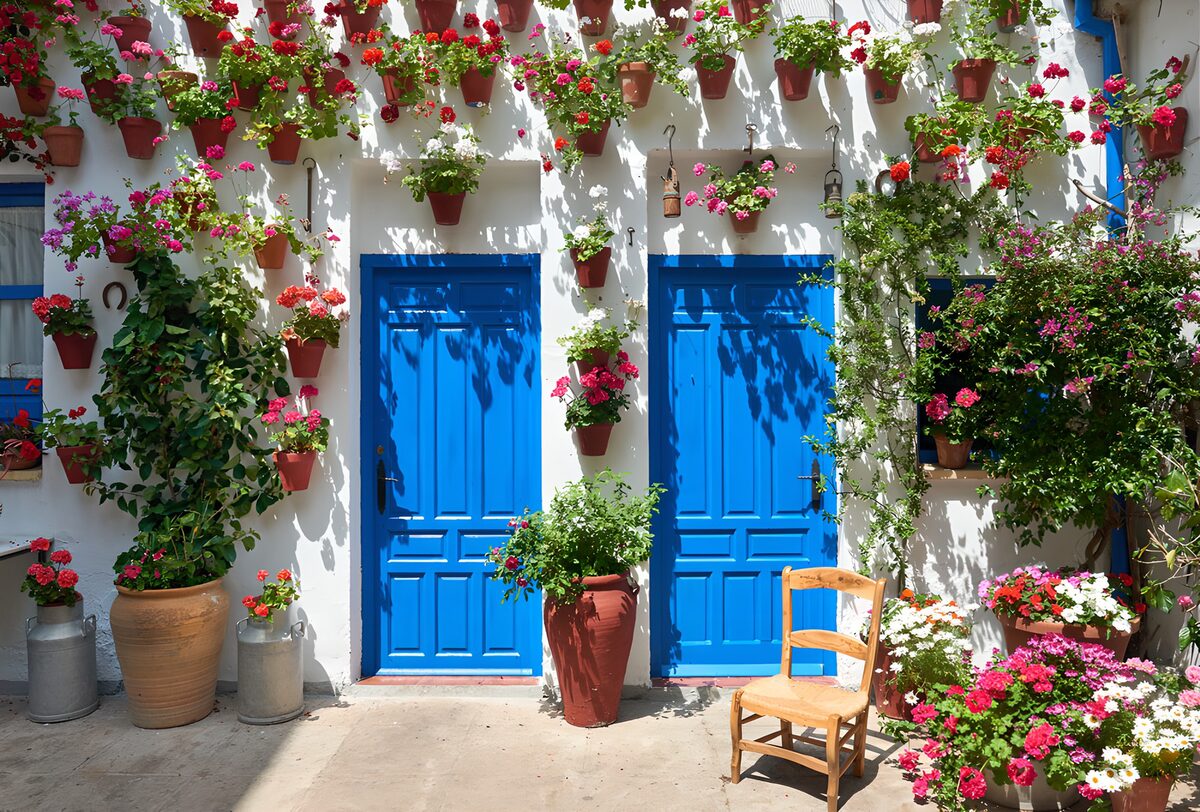Puertas azules entre macetas en flor