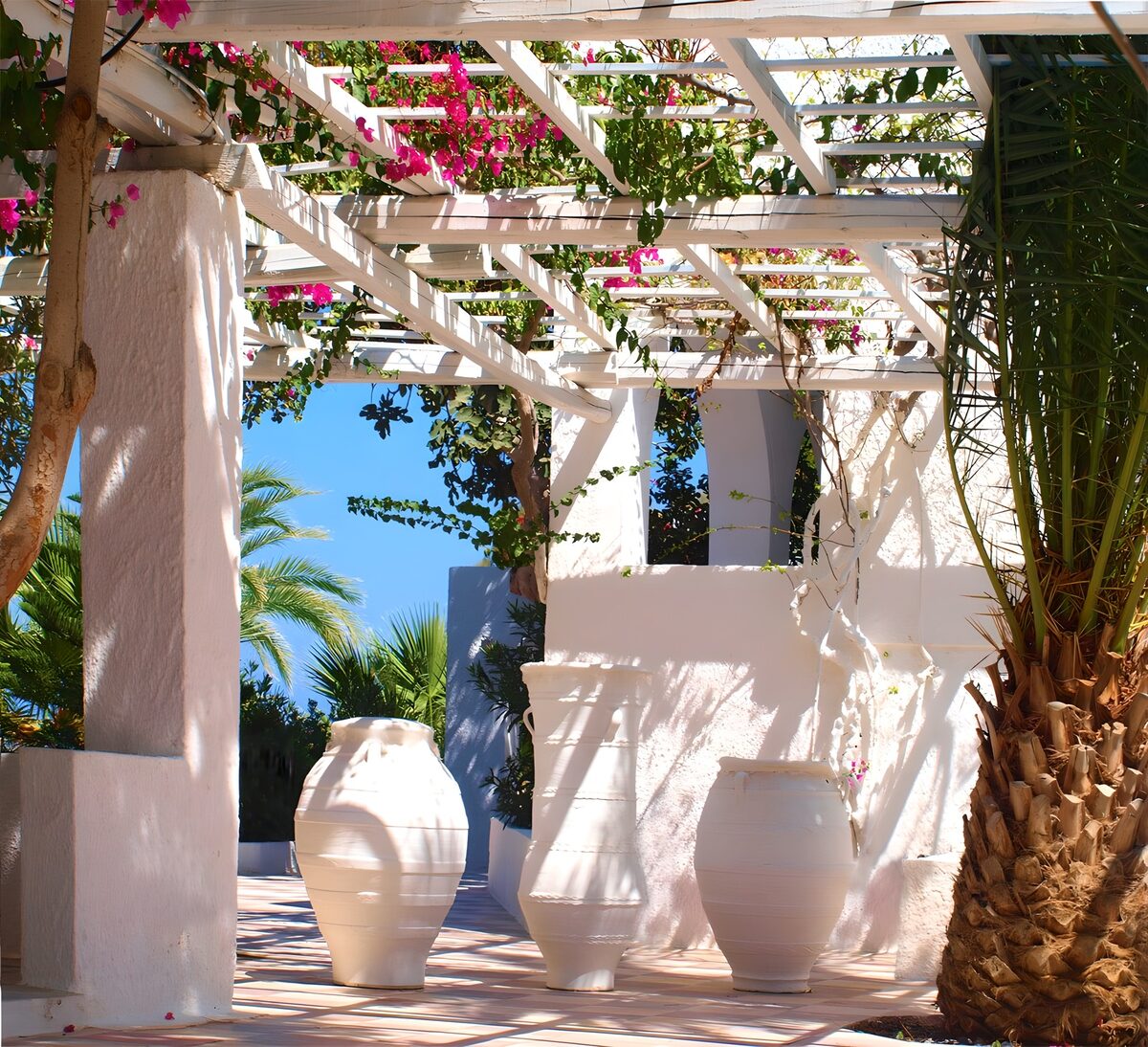 Pérgola blanca con buganvillas al sol