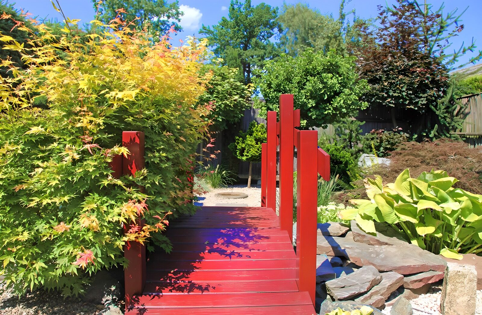 TPES72379: Puente rojo en un jardín frondoso
