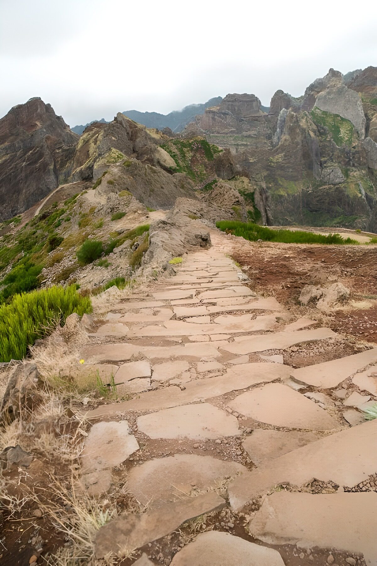 Sendero de piedra entre montañas y niebla