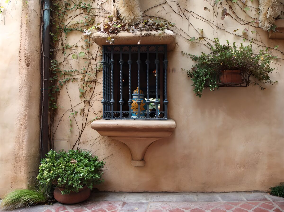 Ventana enrejada en una fachada melocotón