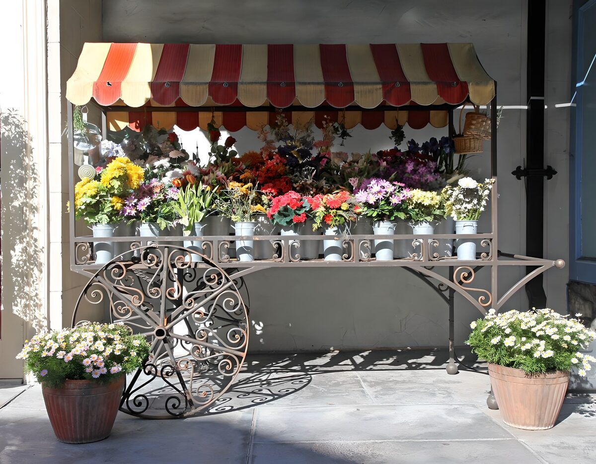 Carrito de flores bajo un toldo de rayas