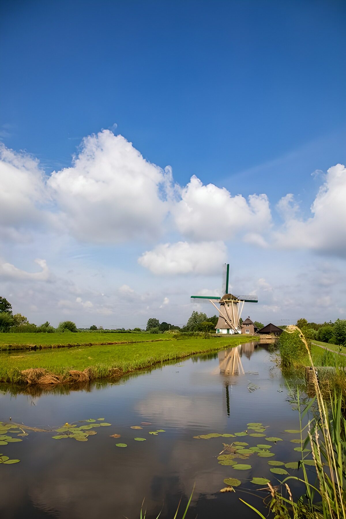 Molino y canal bajo un cielo azul
