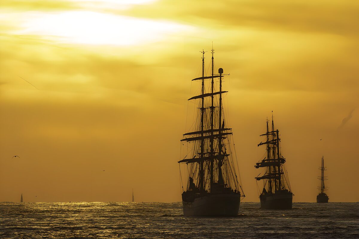 Tres veleros a contraluz al atardecer