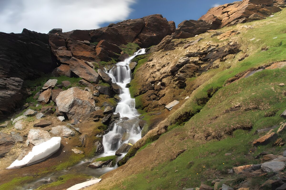 Cascada de montaña entre sol y sombra