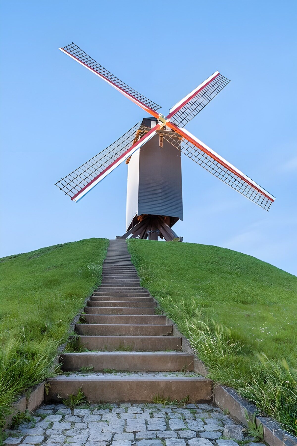 Molino de viento sobre una colina verde