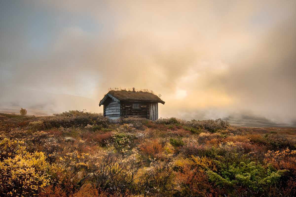 Cabaña de madera entre brumas de otoño