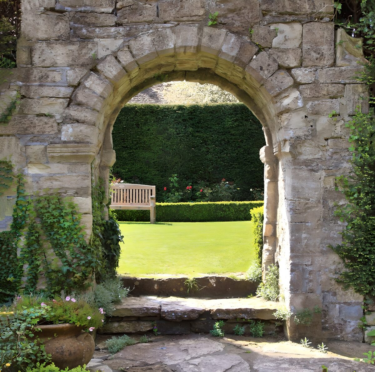 Arco de piedra hacia un jardín al sol