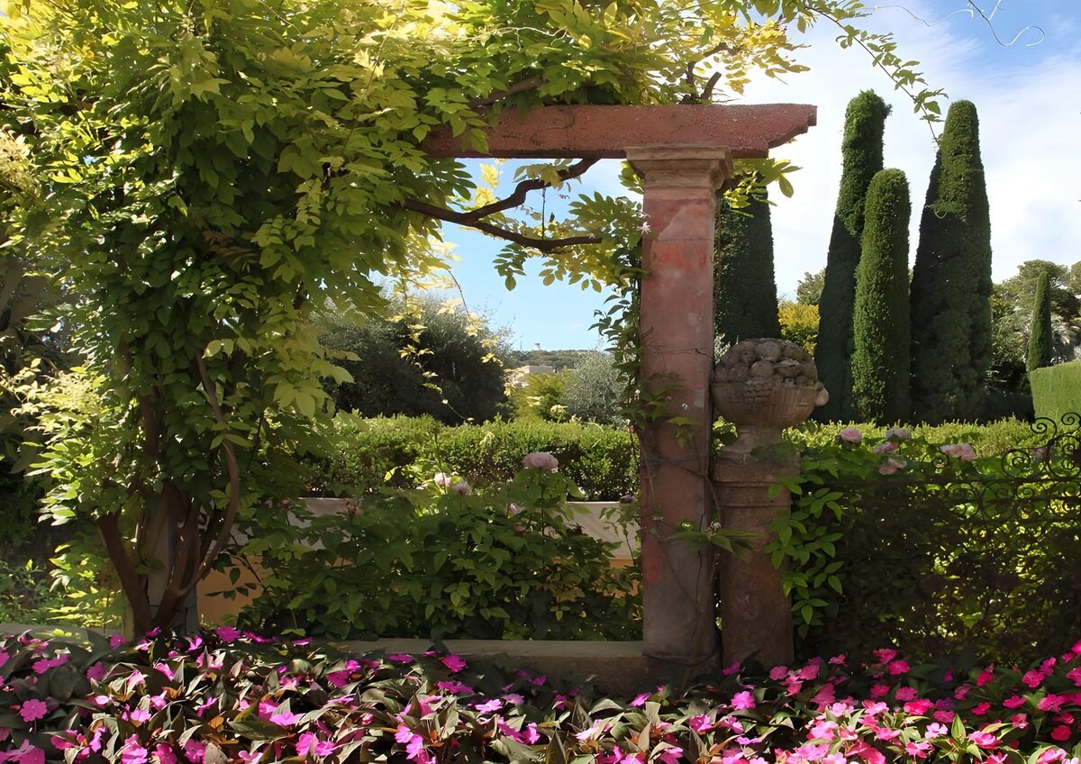 Jardín con pérgola y flores rosas