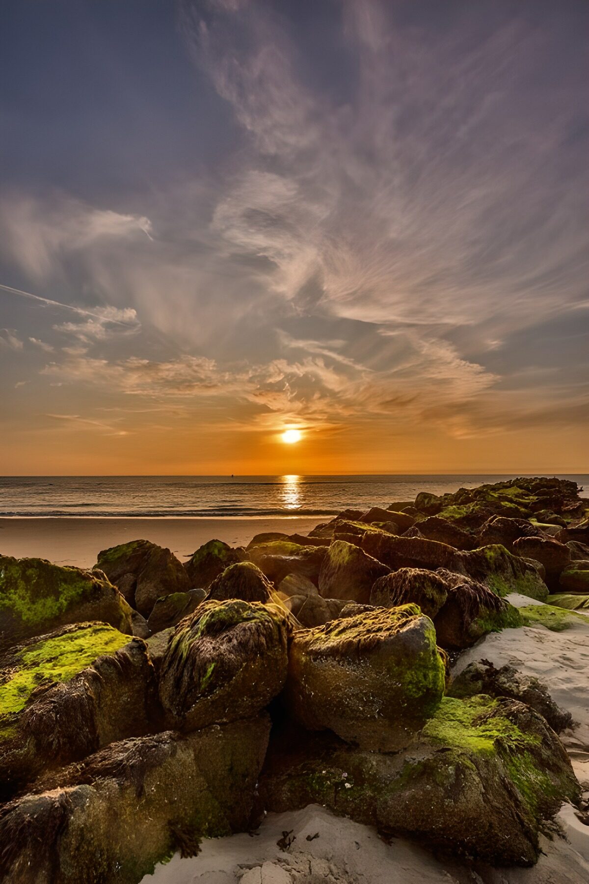 Atardecer entre rocas y olas suaves