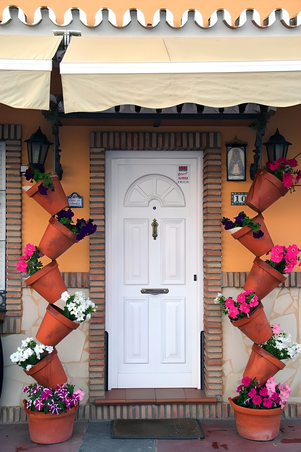 TPES50286: Puerta blanca entre macetas de flores