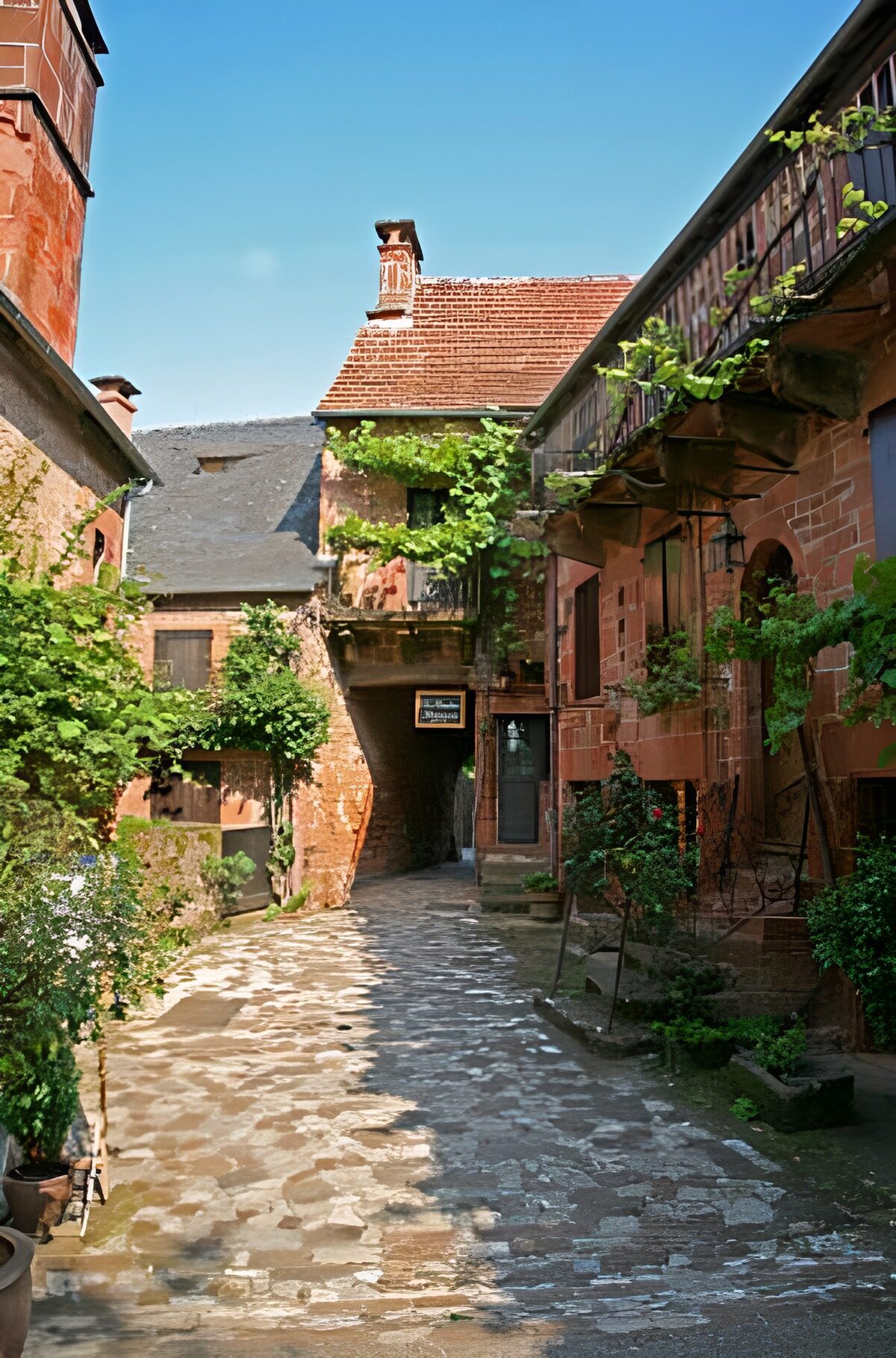Calle empedrada entre fachadas rojizas