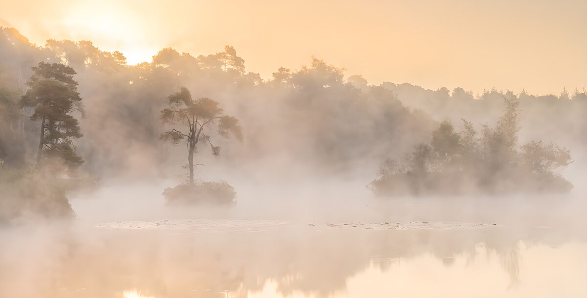 Lago con islas entre la niebla del amanecer