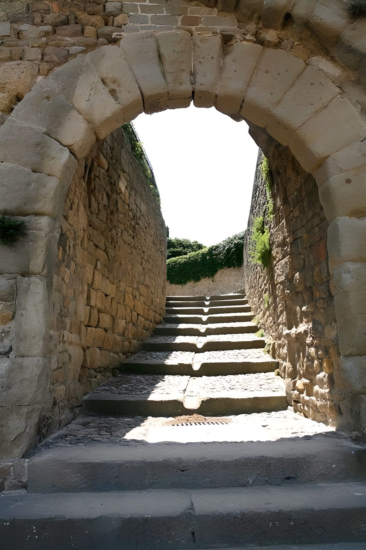 Arco de piedra y escaleras al sol