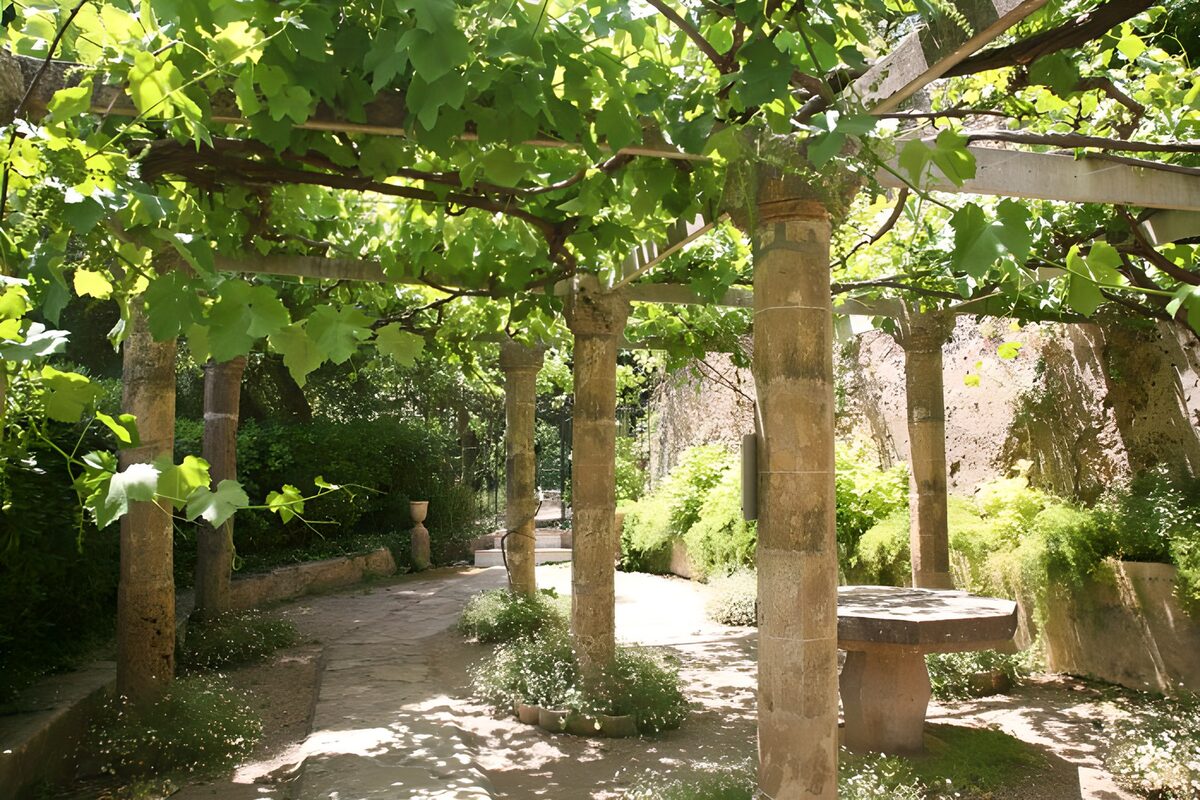 Pérgola de piedra a la sombra de la parra
