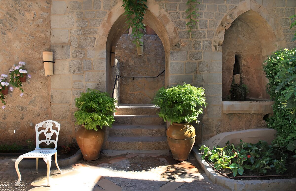 Arcos de piedra y escaleras entre macetas