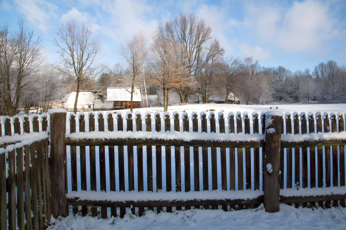 Valla de madera y campo nevado