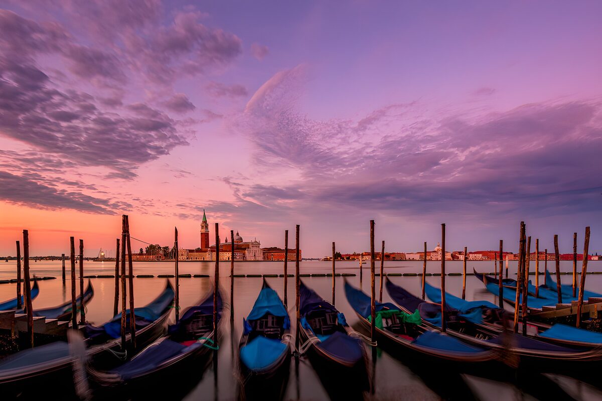 Góndolas al atardecer bajo un cielo violeta