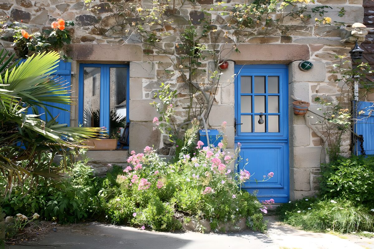 Casa de piedra, puerta azul y jardín
