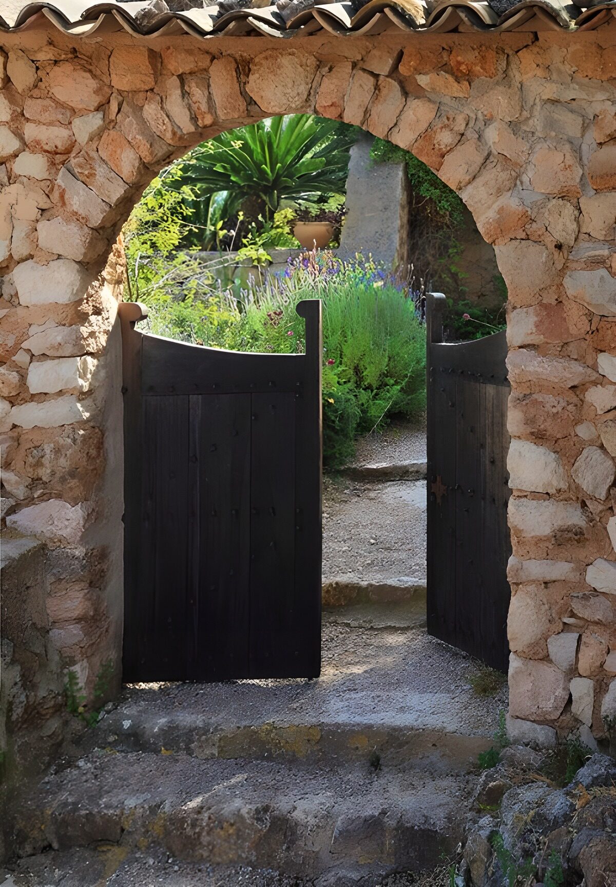 Portón entreabierto bajo un arco de piedra