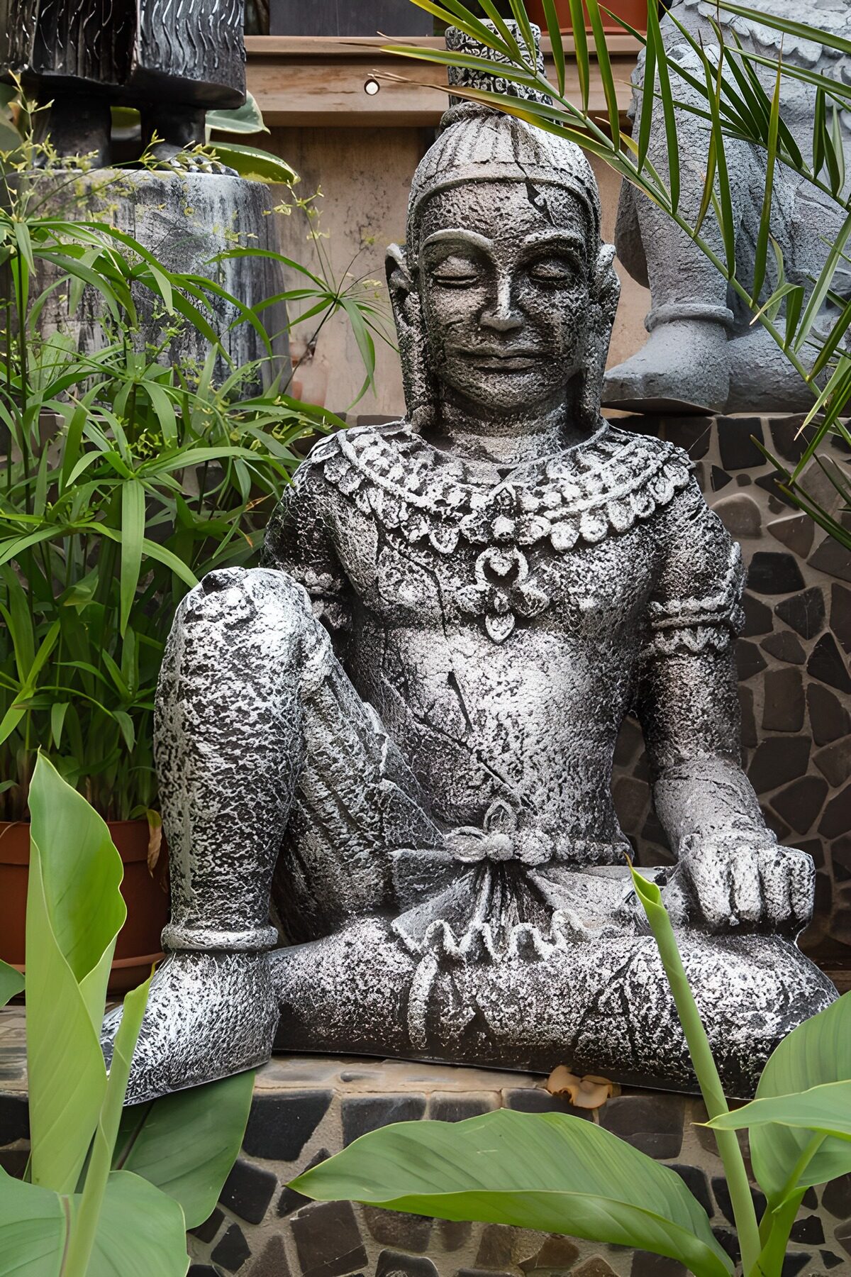 Estatua de piedra gris entre plantas