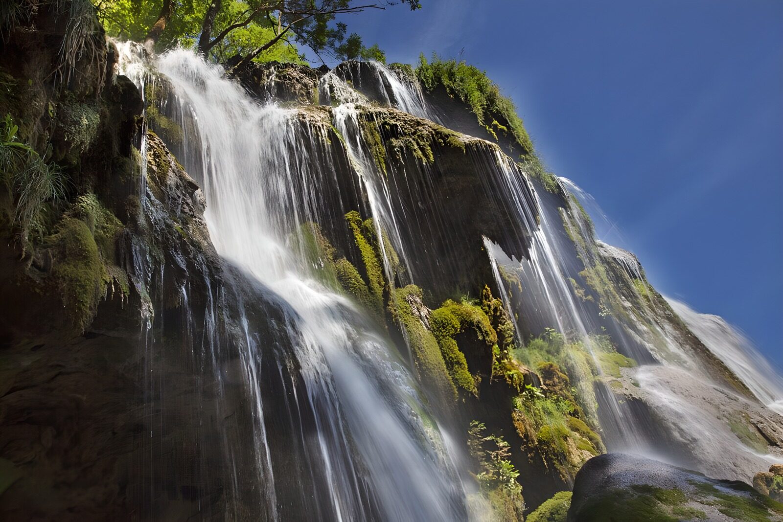 TPES47441: Cascada entre rocas y musgo al sol
