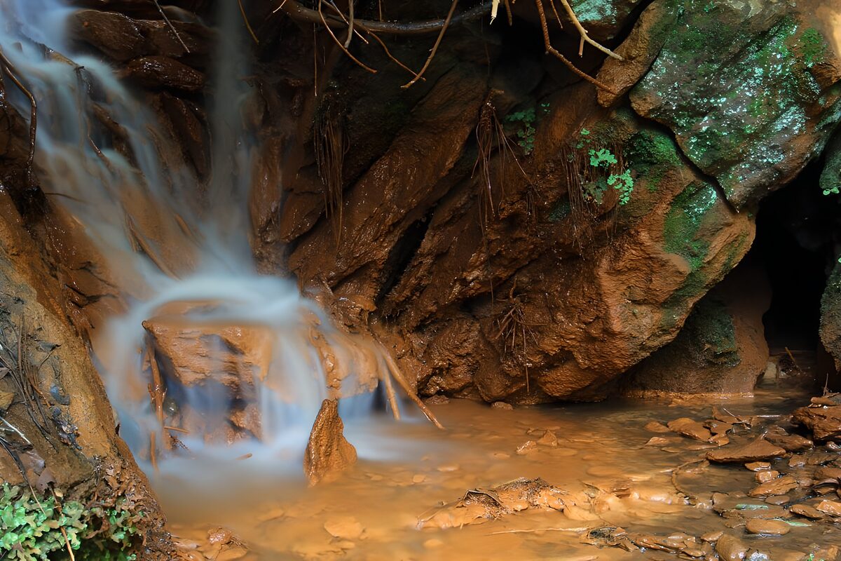 Cascada entre rocas de tonos cobrizos