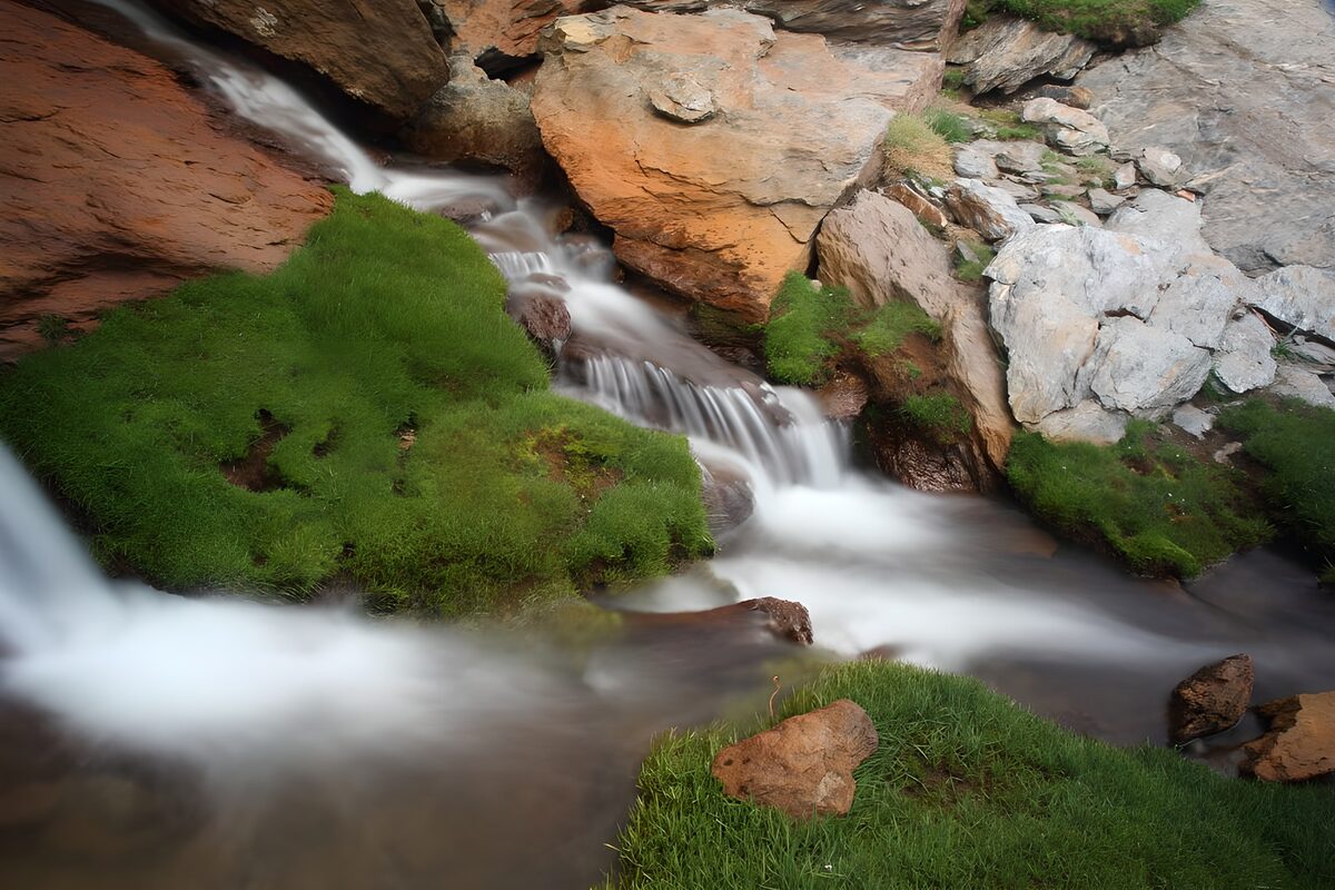 TPES17254: Cascadas entre rocas y hierba verde