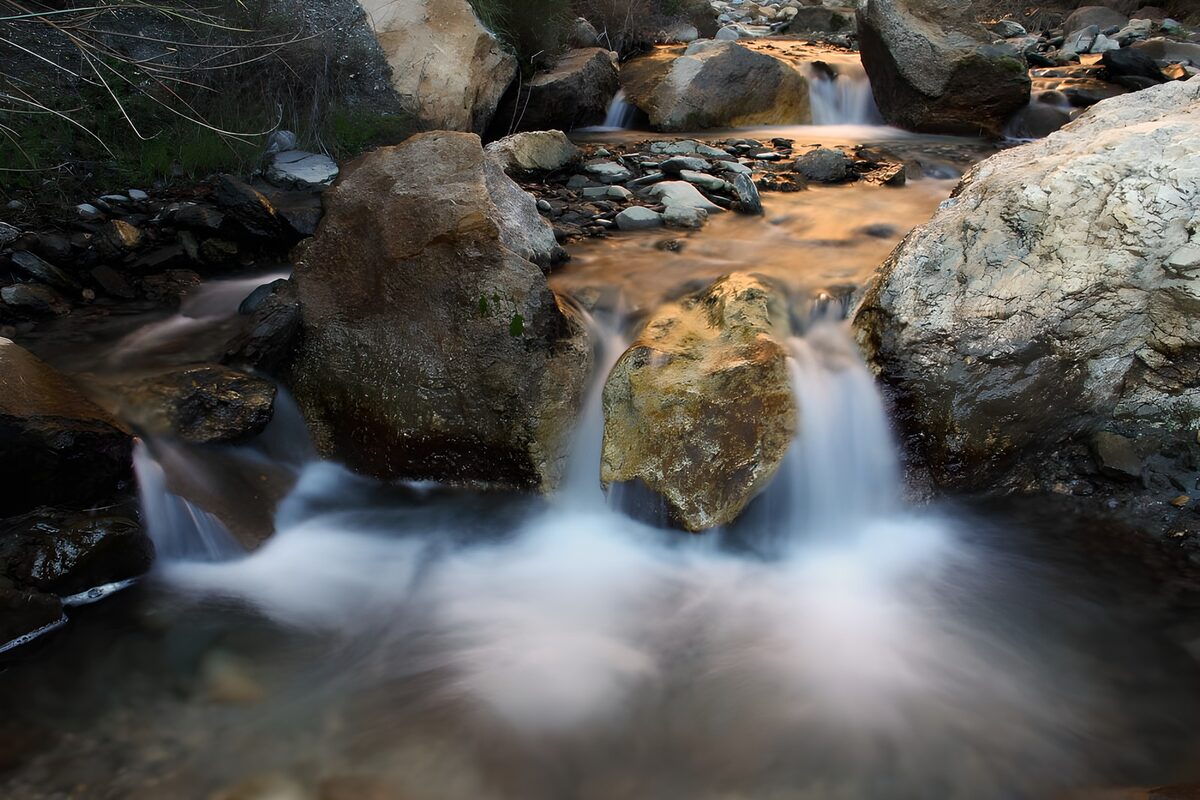 Arroyo entre rocas bajo una luz dorada