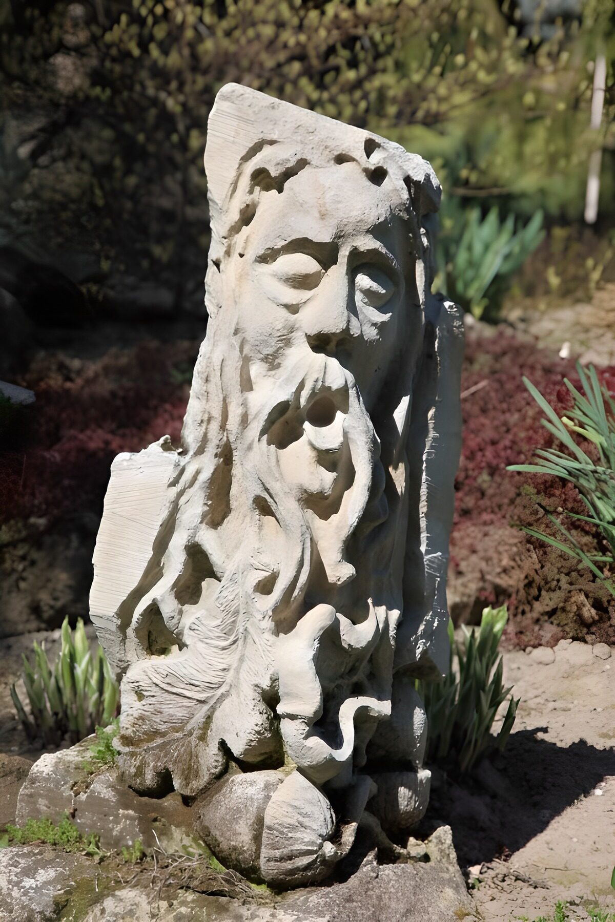 Rostro barbudo de piedra entre sombras