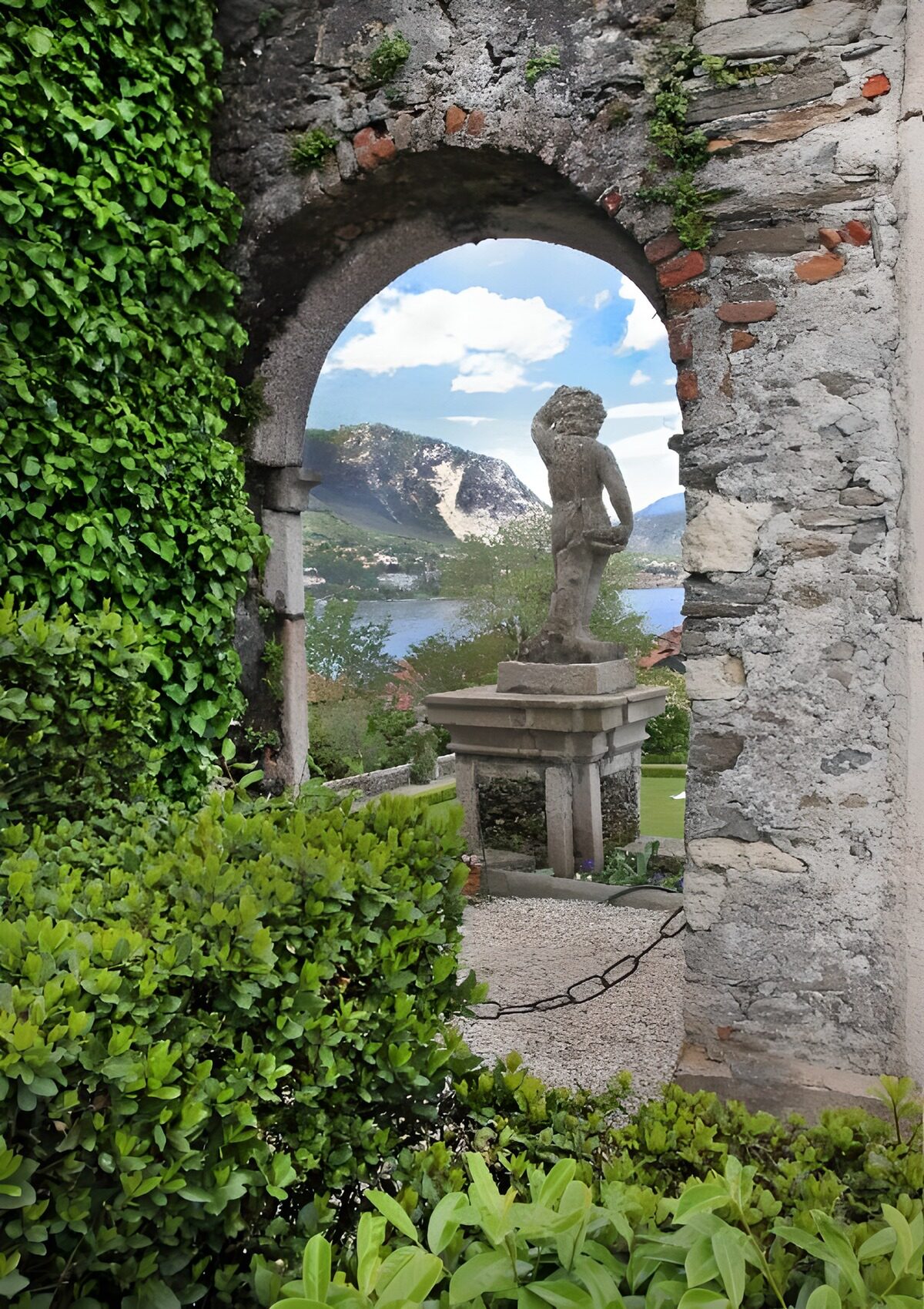 TPES11525: Arco de piedra con estatua junto al lago