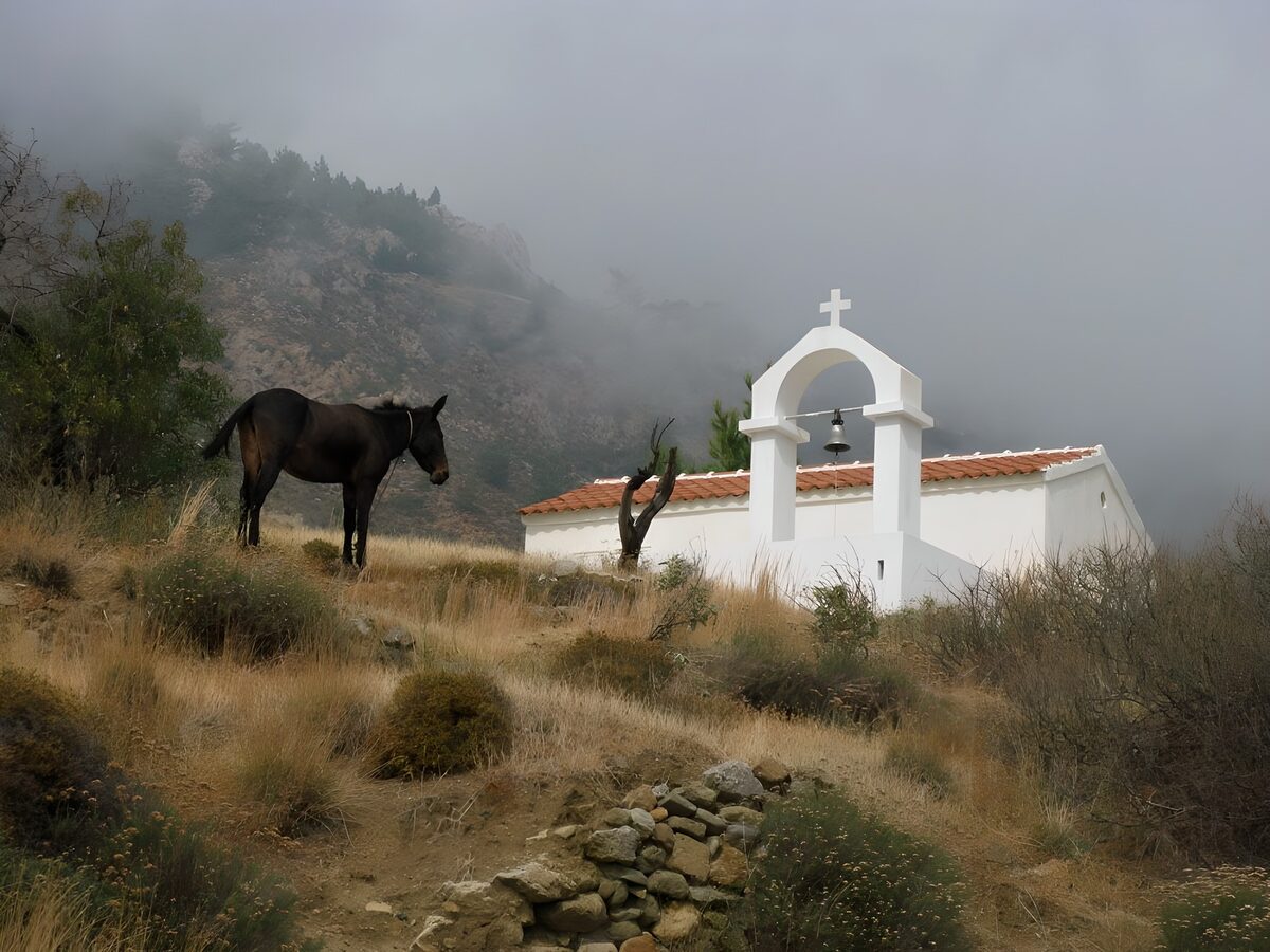 Capilla blanca en una ladera con niebla