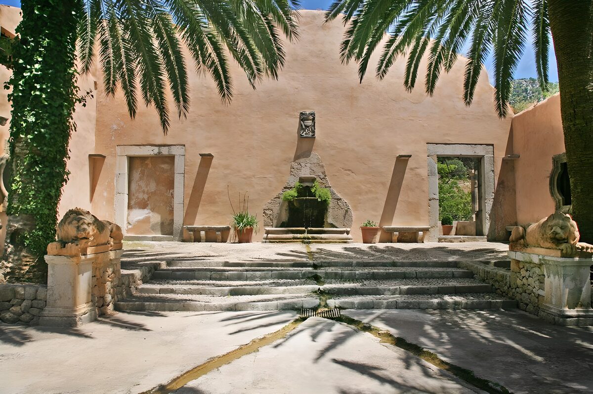 Patio con fuente entre leones y palmeras