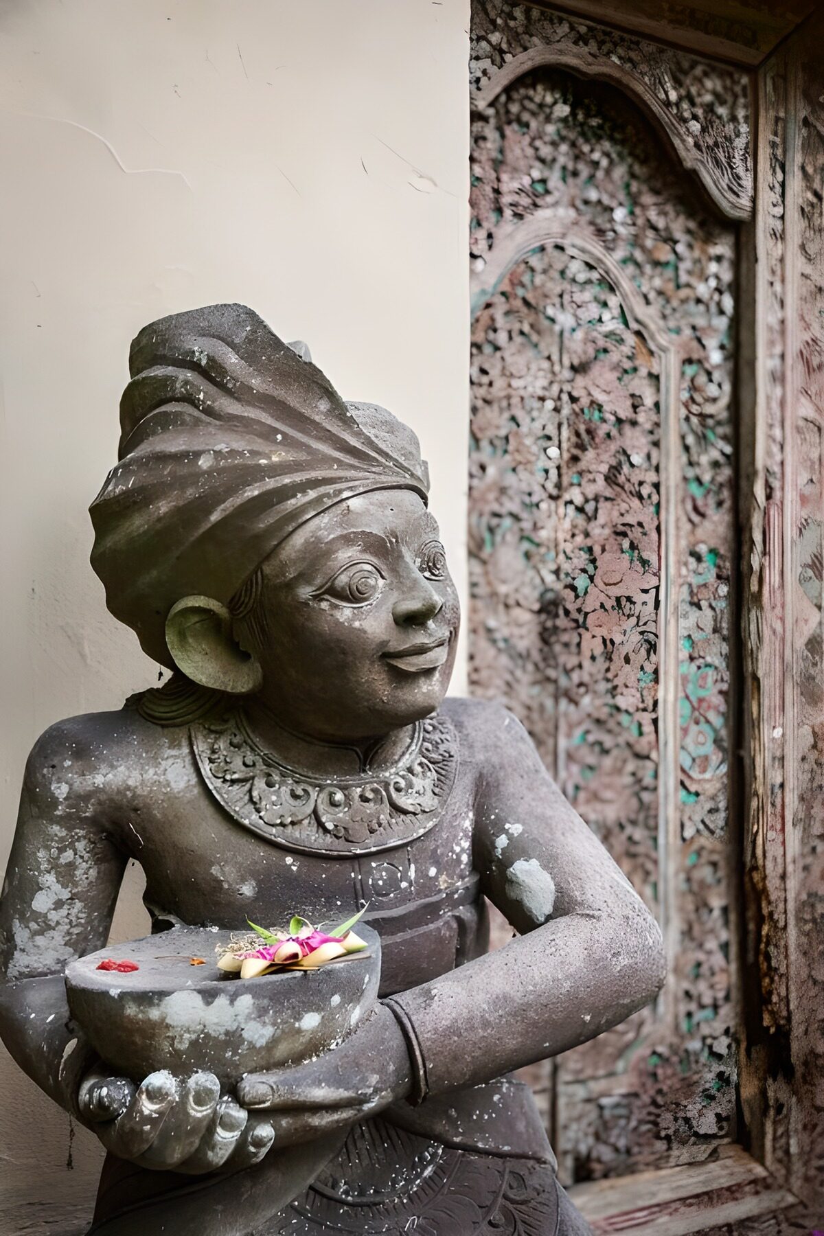 Estatua de piedra con una ofrenda de color