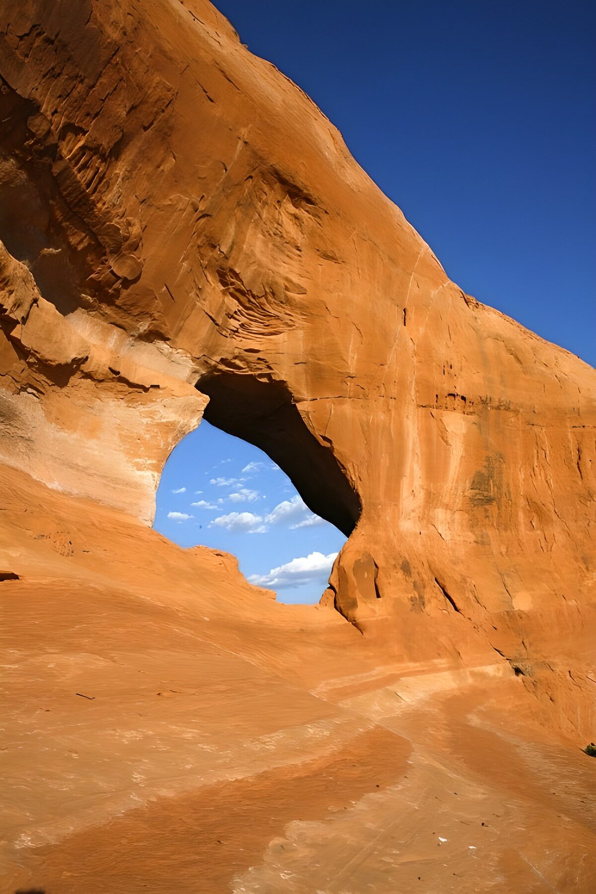 Arco de arenisca naranja bajo el cielo azul