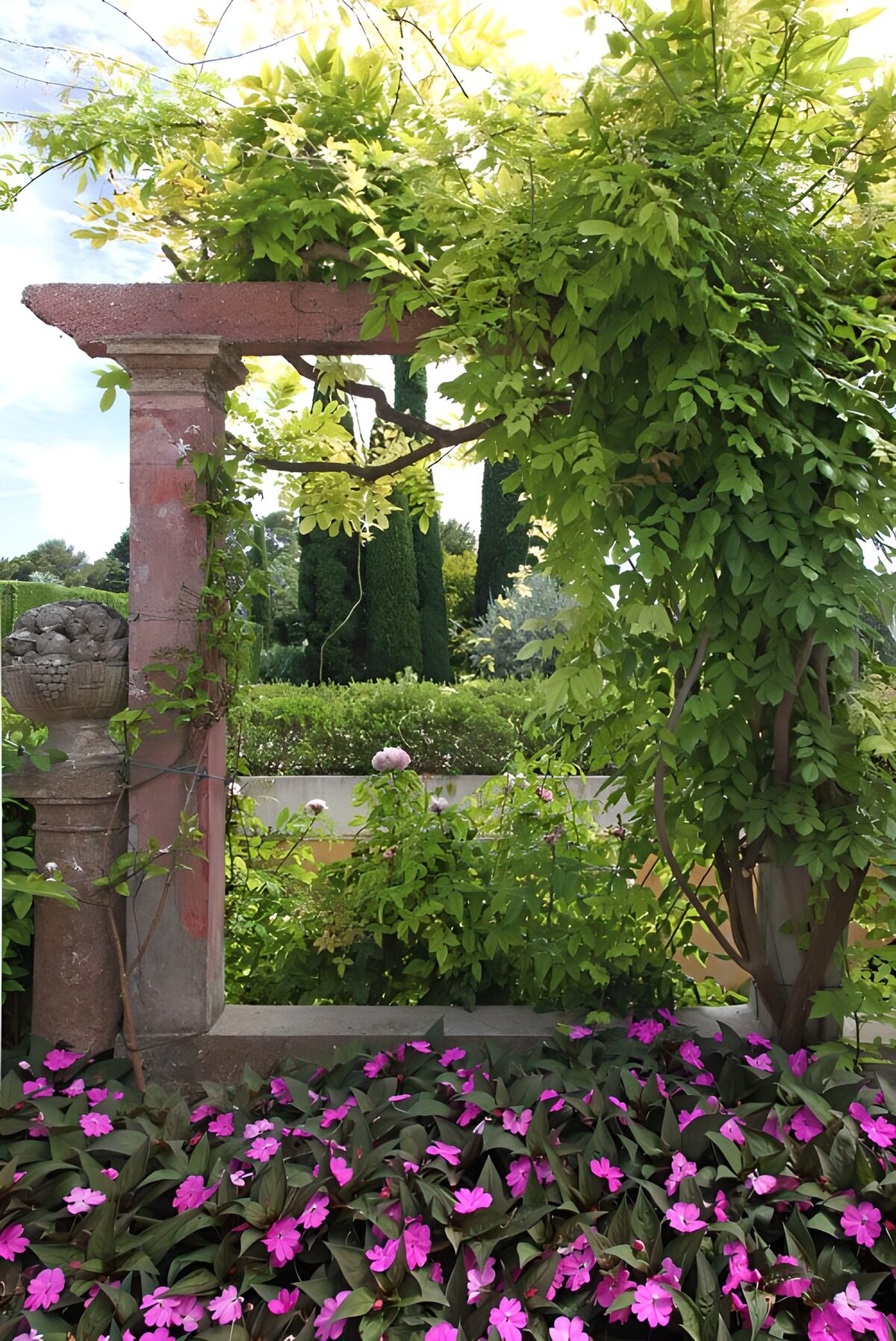 Pérgola de piedra entre flores rosas
