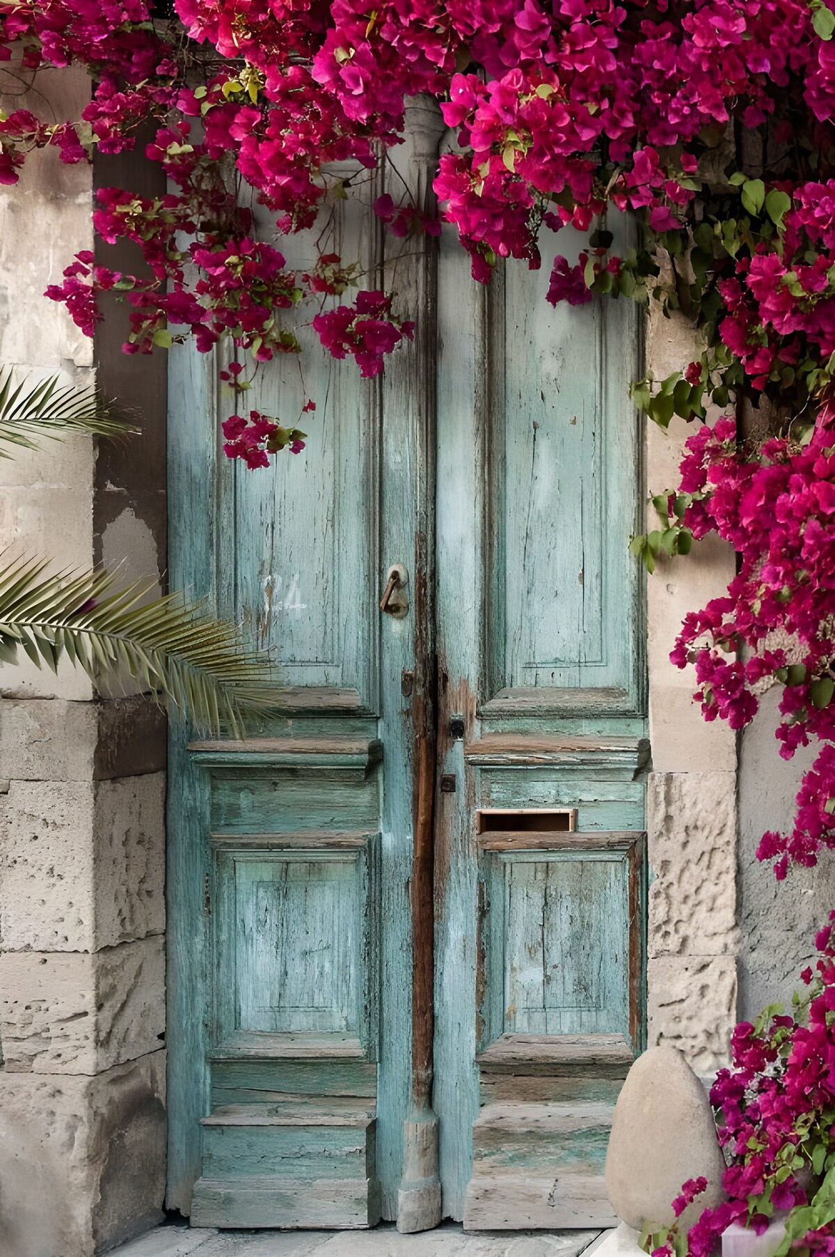 Puerta turquesa envejecida entre flores