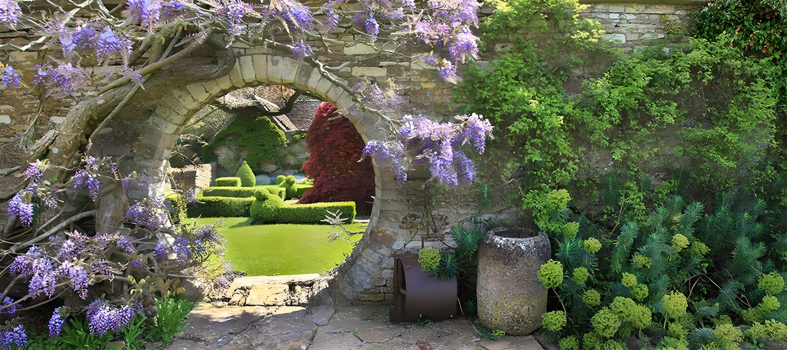 TPES76553: Arco de piedra entre glicinas en flor